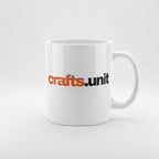 A white ceramic coffee mug with the text 'crafts.unit' printed on the side in orange and black, set against a clean white background.