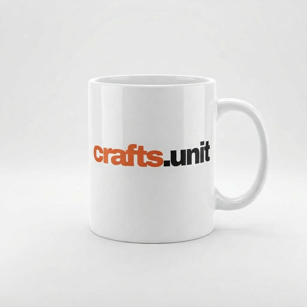 A white ceramic coffee mug with the text 'crafts.unit' printed on the side in orange and black, set against a clean white background.