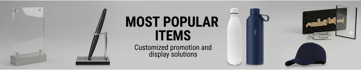 Promotional display solutions featuring clear acrylic panels mounted on gray bases, shown alongside Arabic text on a black plaque and a small keychain, with the headline 'MOST POPULAR ITEMS' on a light gray background.